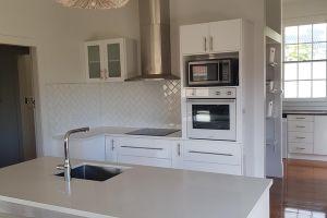 New kitchen with tiled splashback and pantry in behind kitchen